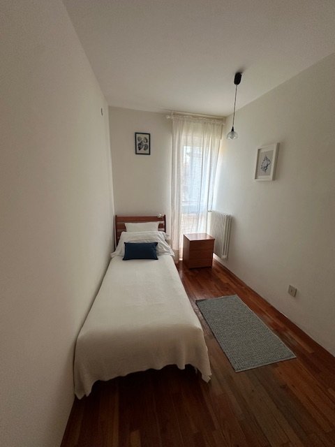 Room with single bed and parquet floor of the apartment in Grado