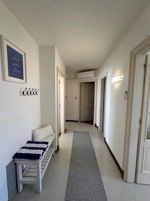 Internal hallway of the apartment in Grado with bench and furnishings
