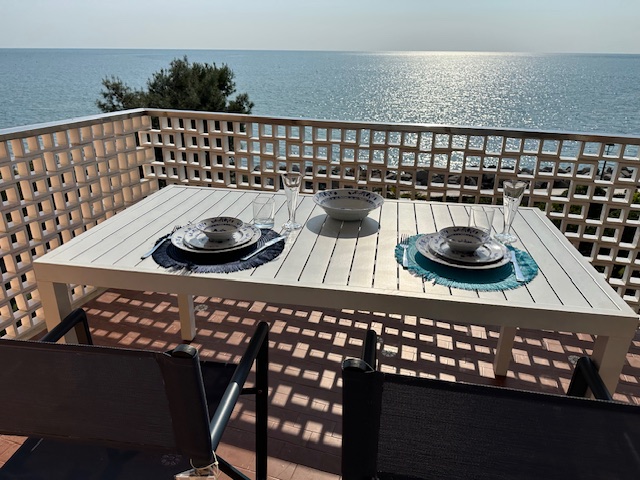 Terrazza dell'appartamento Colazione sul mare a Grado, con tavola apparecchiata e vista sul mare al tramonto