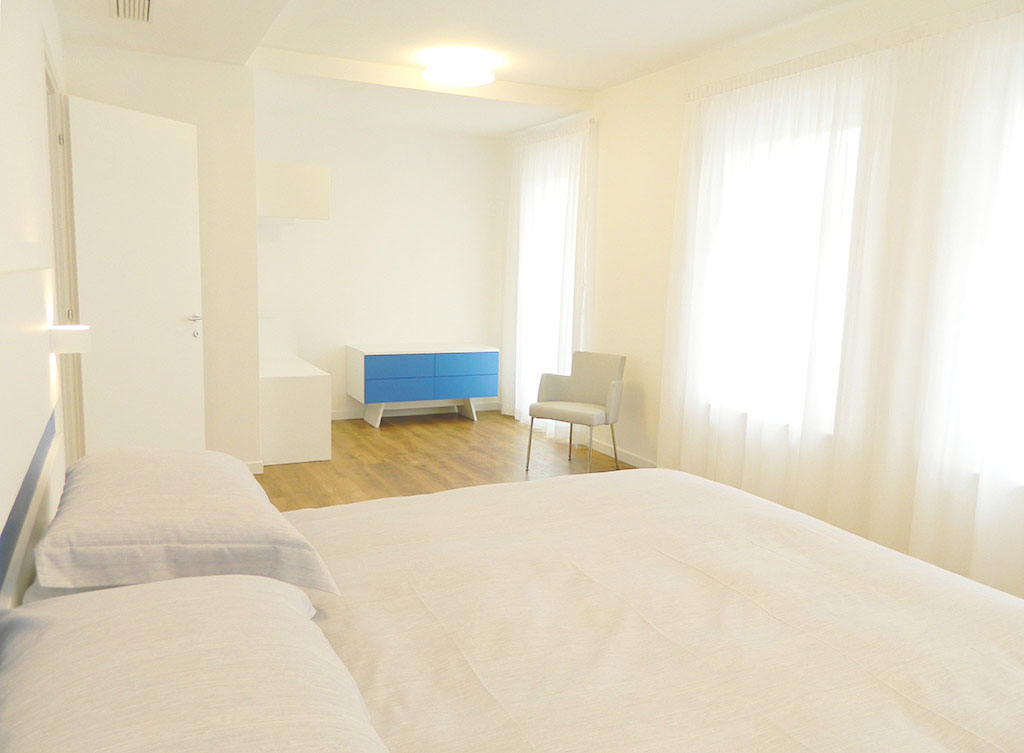 Geräumiges Schlafzimmer des Deluxe-Apartments mit Leseecke, Palamostre Residence, Udine